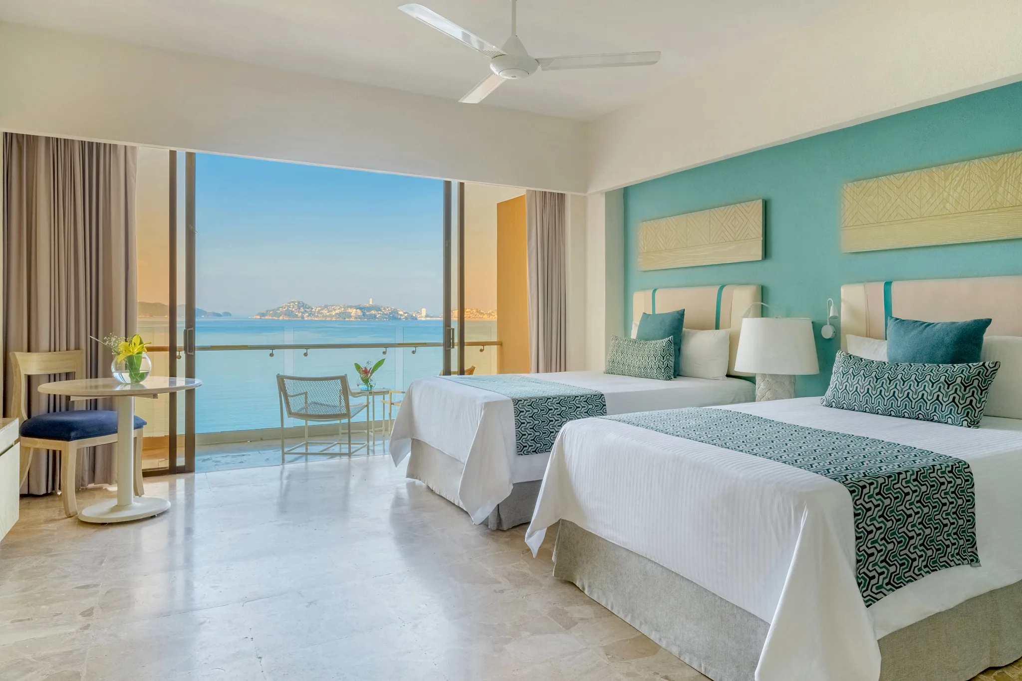 Deluxe Ocean View room with two double beds and private balcony at Dreams Acapulco Resort & Spa overlooking Acapulco Bay.