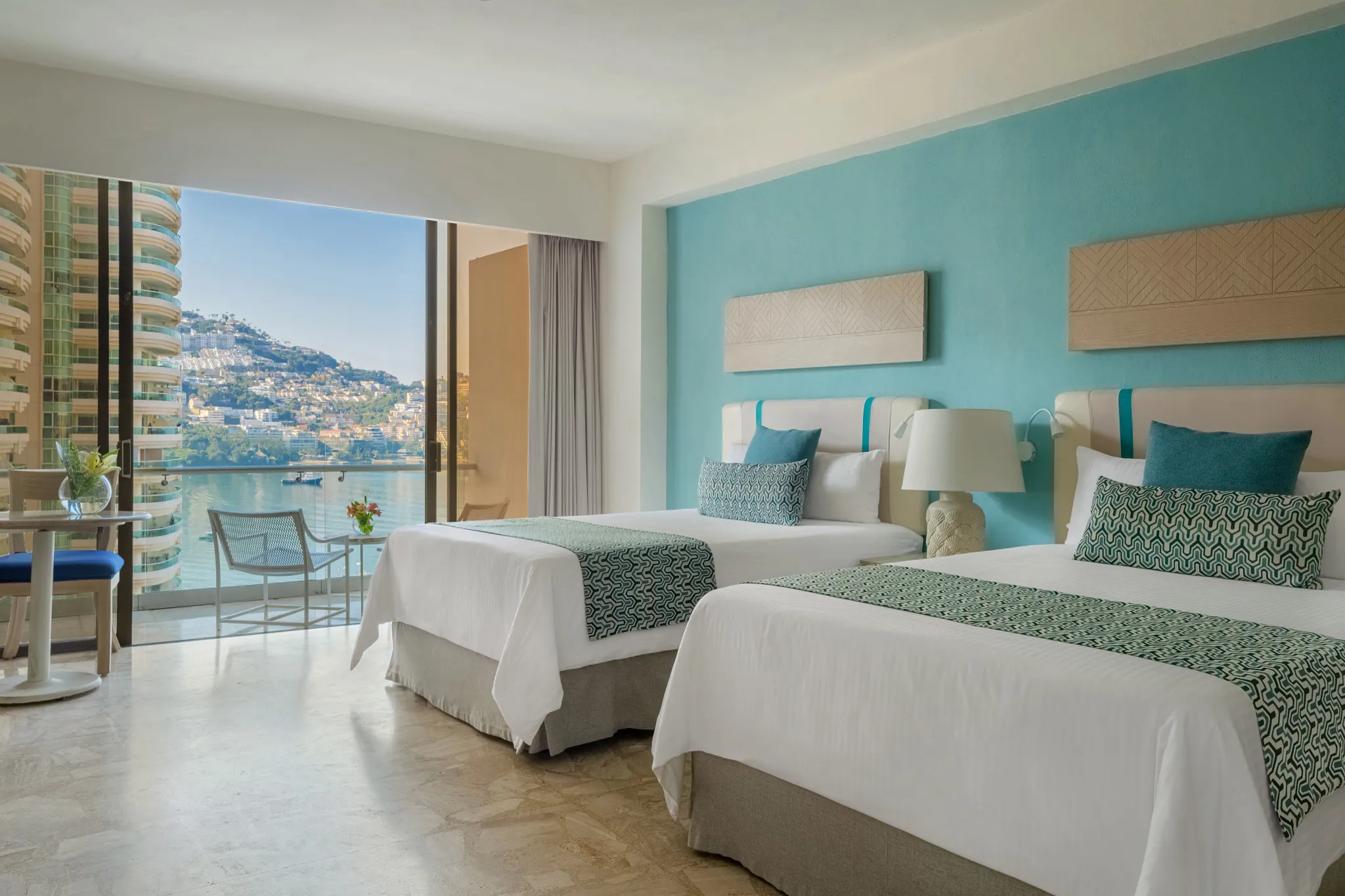 Deluxe Partial Ocean View room with two double beds and private balcony at Dreams Acapulco Resort & Spa.