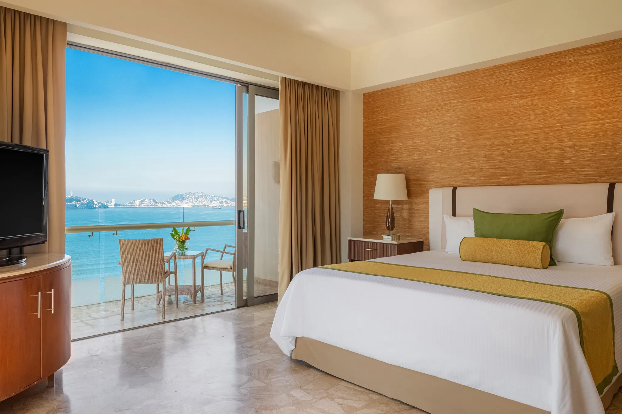 Preferred Club Family Suite Ocean View king bedroom with furnished balcony at Dreams Acapulco Resort & Spa.